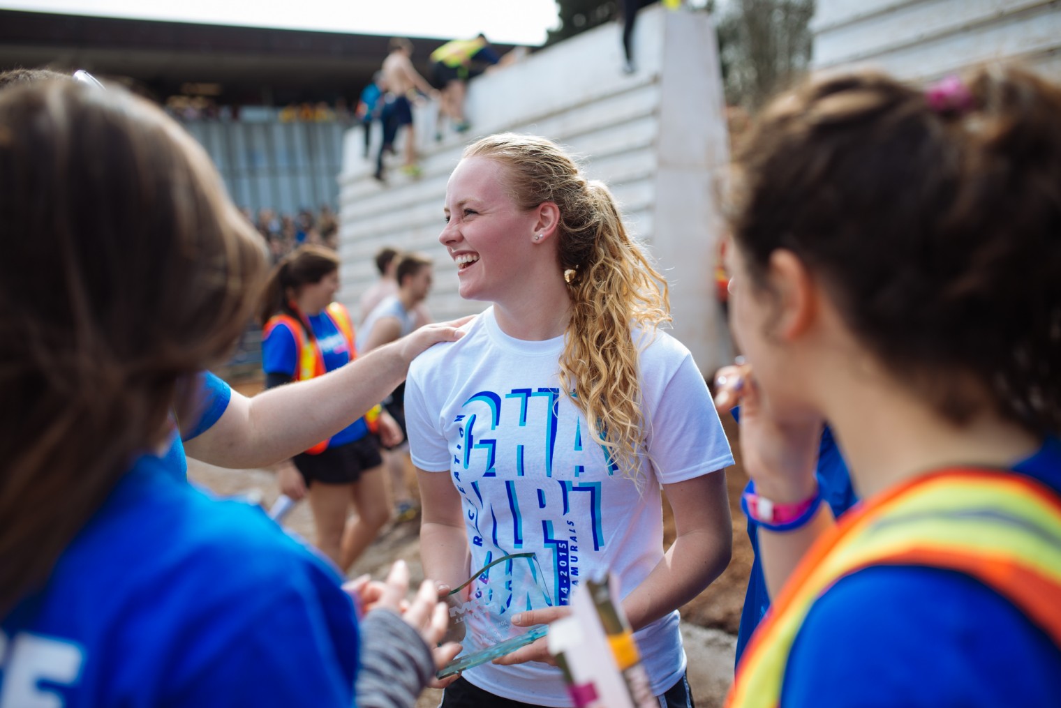 Storm the Wall winner holds trophy as she is congratulated by friends