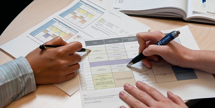 Image two people's hands going over research papers