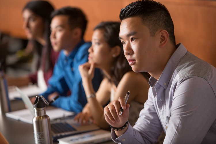 Students listen attentively and take notes during a class lecture