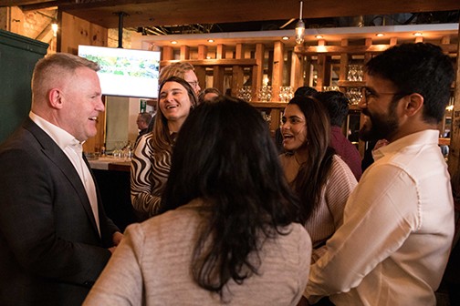 Dean Darren Dahl chatting with attendees at event, smiling