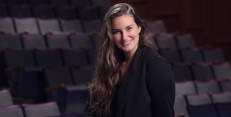 Image of Emily Peck sitting in an empty theatre